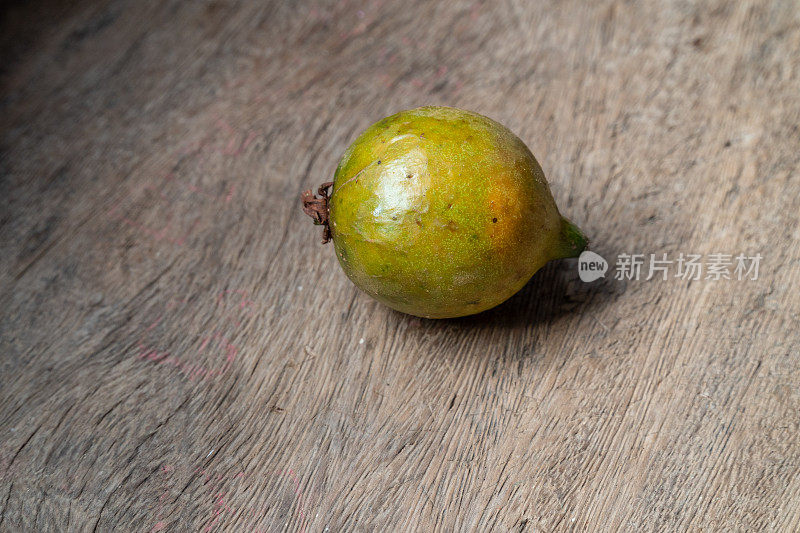 特写的异国水果Grugru坚果“澳门”“Acrocomia aculeata”木质背景。来自巴西本土的一种棕榈树被用作食物，其油用于生产生物柴油。